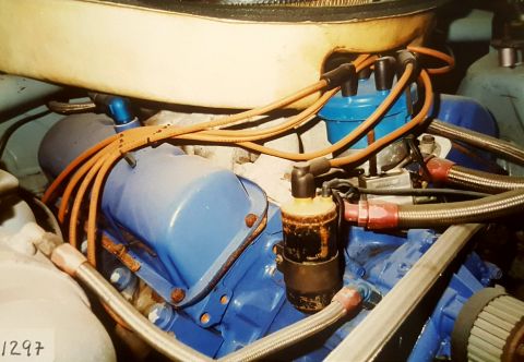 1973 Ford Mustang - Engine bay detail showing ignition system parts and blue painted engine block.