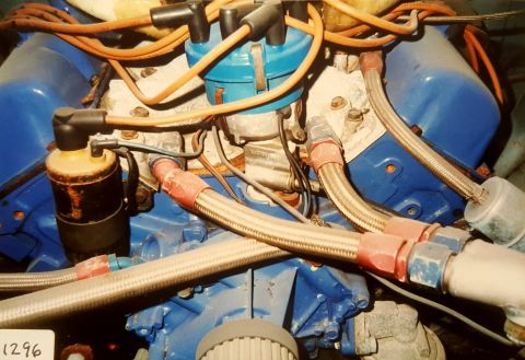 1973 Ford Mustang - A close-up view of an engine bay, highlighting the distributor, spark plug wires, and braided hoses.