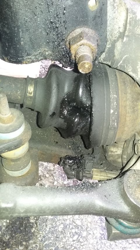 Torn CV boot with grease splatter