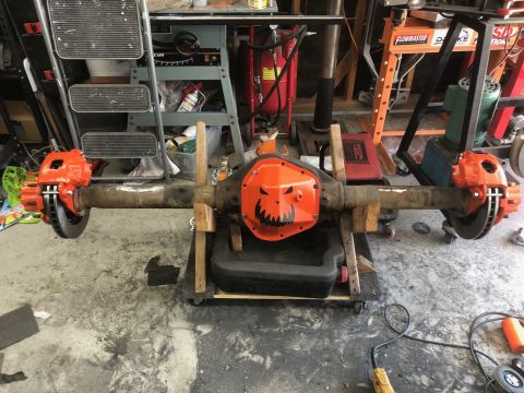 1992 Jeep Wrangler - Differential housing with a custom jack-o'-lantern differential cover and bright orange brake calipers is displayed in a workshop.