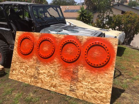 1992 Jeep Wrangler - A Jeep is parked behind a piece of plywood that has four orange circles spray-painted on it.