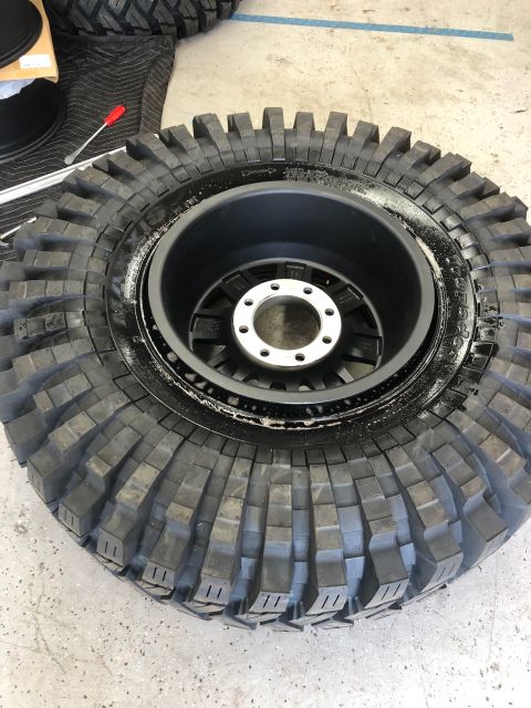 1992 Jeep Wrangler - Close-up of a large off-road tire and wheel assembly, likely for a Jeep Wrangler, being prepared for installation.