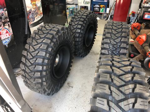 1992 Jeep Wrangler - Several large off-road tires are shown, some mounted on black rims, in what appears to be a garage or workshop.