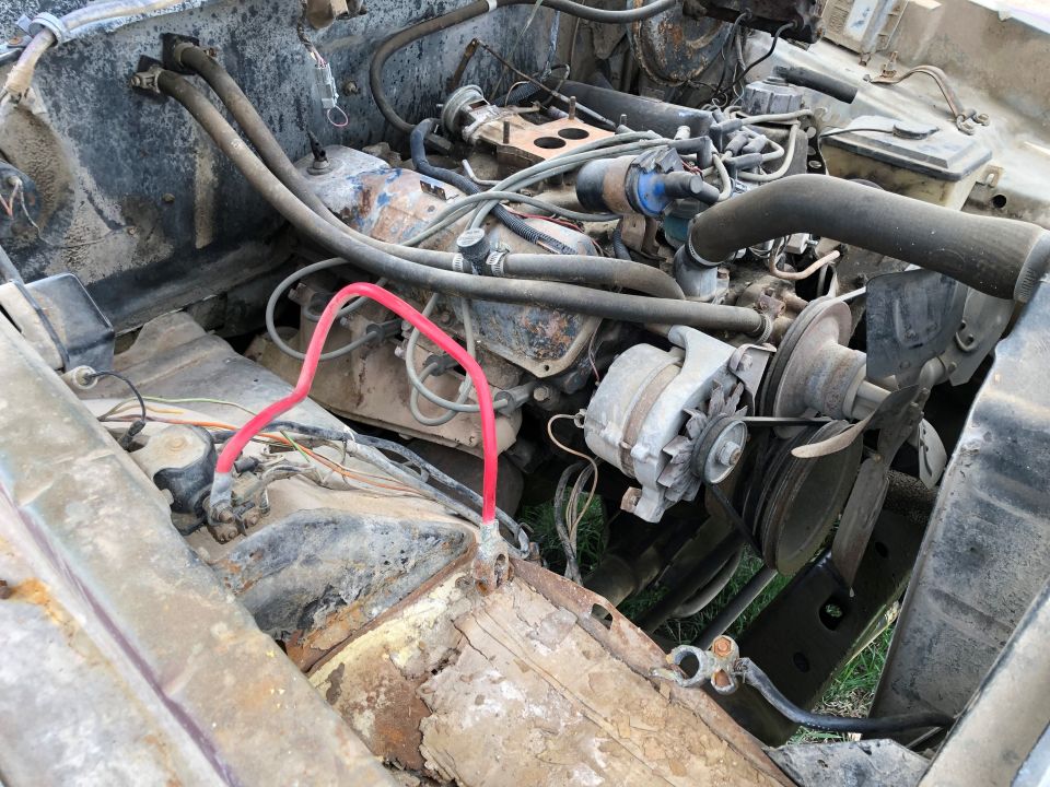 Engine bay with alternator and hoses. Watermark 'SUPER MOTORS'