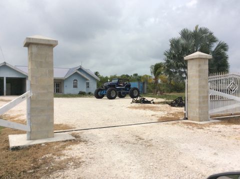 1992 Ford Bronco - A custom-built monster truck sits in a gravel driveway near a house and gate.