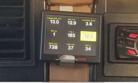1985 Ford Bronco - A digital gauge displays engine parameters like RPM, AFR, and fuel flow, along with battery voltage.