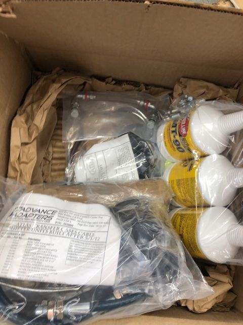 1992 Jeep Wrangler - Contents of a box containing automotive parts, including Red Line MT-90 oil and an Advance Adapters transfer case cable kit.