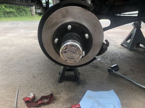 1995 Ford Bronco - Vehicle brake rotor and hub assembly with tools nearby, likely during a repair.
