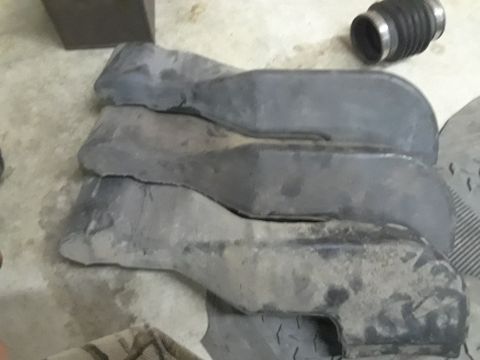 1994 Ford Bronco - These appear to be intake or exhaust components, possibly for an older vehicle, laid out on a garage floor.