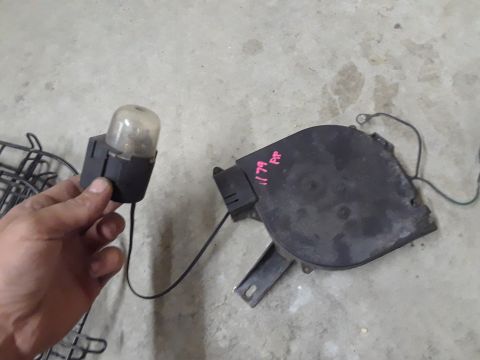1994 Ford Bronco - Two automotive parts are shown on a concrete surface, one held by a hand.