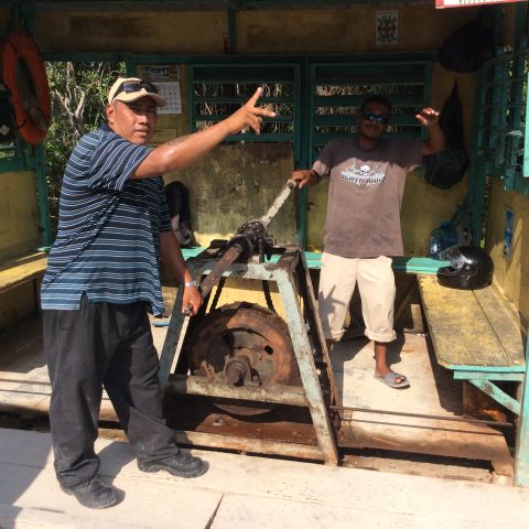 1992 Ford Bronco - Two men are posing with a winch mechanism in a rustic outdoor shelter.