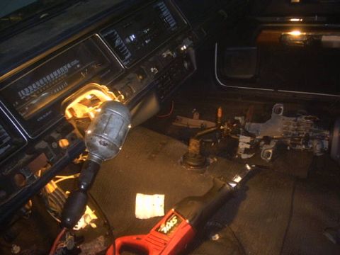 1991 Ford LTD Crown Victoria - Interior view of a car with the steering column disassembled and tools present.