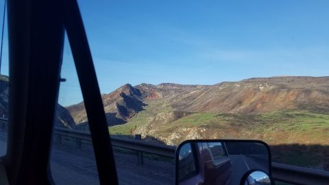 1985 Ford Bronco - Reflection in the side mirror shows the truck bed and a scenic mountain view.