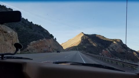 1985 Ford Bronco - Driving through a scenic mountain pass on a clear day.