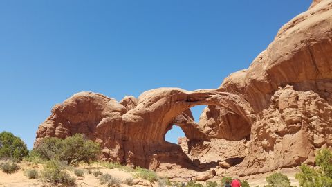 1985 Ford Bronco - The iconic Double Arch in Arches National Park, Utah, stands majestically against a vibrant blue sky.