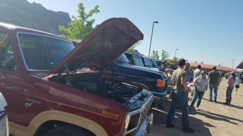 1985 Ford Bronco - A maroon Ford Bronco is parked with its hood up, revealing the engine compartment.