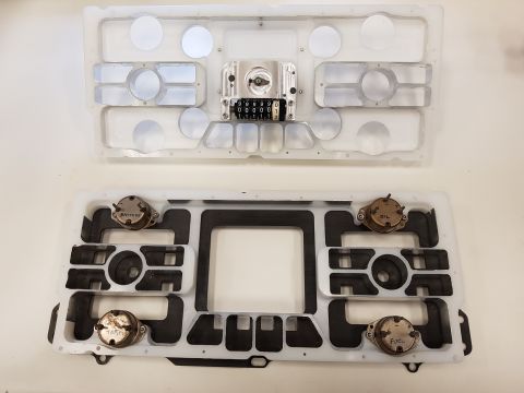 1978 Ford Bronco - Disassembled dashboard components, including an odometer and sending units for fuel and oil, are laid out for inspection.