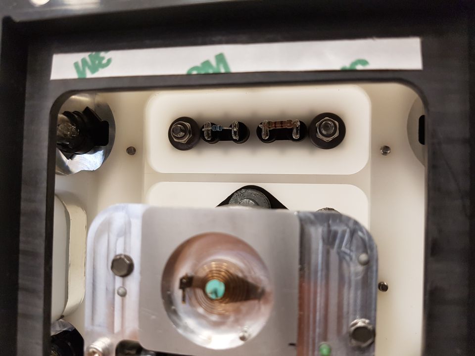 Close-up of an automotive electrical component with resistors and wiring visible. A '3M' logo is on a strip of tape