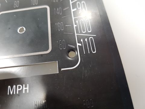 1978 Ford Bronco - A close-up of a black gauge cluster with white lettering and markings. Visible text includes "MPH", "100", "110", and "180".