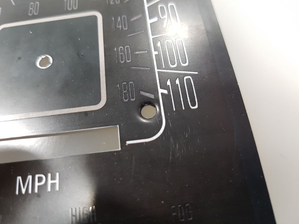 Close-up of a black vehicle gauge cluster with white MPH markings and numbers.