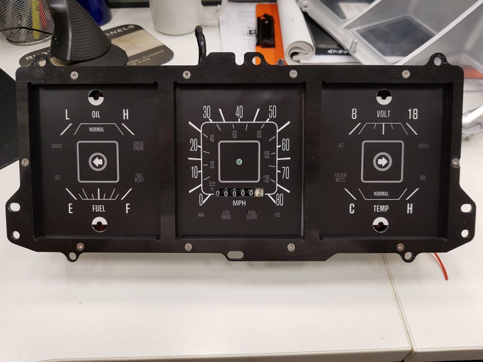 Vintage vehicle instrument cluster with multiple gauges and indicator lights.