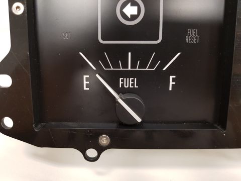 1978 Ford Bronco - A close-up view of a black fuel gauge with white markings. The needle is pointing between E (empty) and F (full), indicating a low fuel lev…