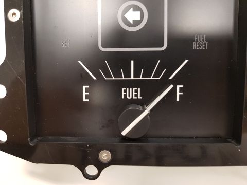 1978 Ford Bronco - A close-up view of a black fuel gauge with white markings for 'E' (empty) and 'F' (full). The needle is pointing between 'E' and 'F', indic…