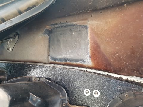 1978 Ford Bronco - This is a close-up view of the firewall area of a 1978 Ford Bronco, showing a patch of bare metal where rust has been removed, surrounded b…