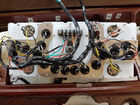 1978 Ford Bronco - A custom wiring harness is connected to a white panel with multiple gauges and electrical terminals, likely for a vehicle dashboard. The pa…
