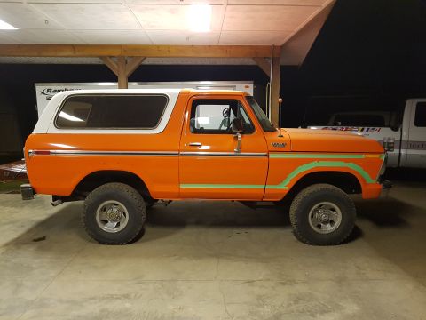 1978 Ford Bronco - This 1978 Ford Bronco features a two-tone orange and white paint scheme with distinctive green stripe accents along the body.
