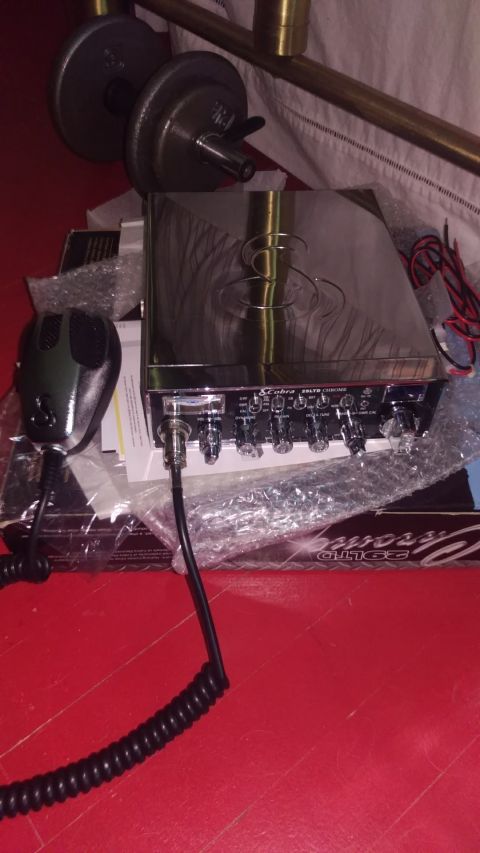 1988 Ford Bronco - A chrome CB radio and microphone are shown on a red surface, with some packaging and weights in the background.