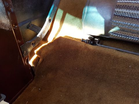 1978 Ford Bronco - Interior view of a vehicle with brown carpet and patterned seat fabric.