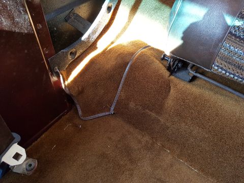 1978 Ford Bronco - Close-up of the interior floor and seat mounting hardware, showing carpet details.