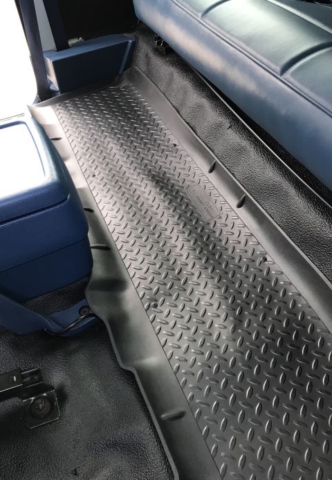 1995 Ford Bronco - Interior view of a vehicle a diamond plate floor mat and blue upholstery.