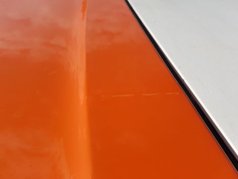 1978 Ford Bronco - Close-up of a two-tone vehicle's hood and fender seam.