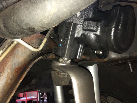 1995 Ford Bronco - Underside view of a vehicle's steering mechanism, focusing on the gear box and connecting rod.
