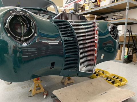 1940 Ford Coupe - Front end of a 1940 Ford Coupe undergoing repairs, with the grille and headlight assembly visible.