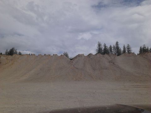 1995 Ford Bronco - A white SUV navigates a steep dirt incline under a cloudy sky.