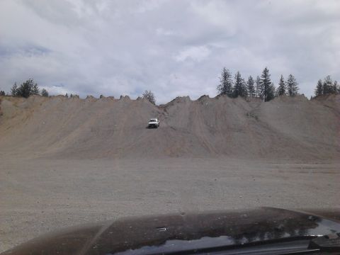 1995 Ford Bronco - SUV navigates a steep dirt incline under a cloudy sky.