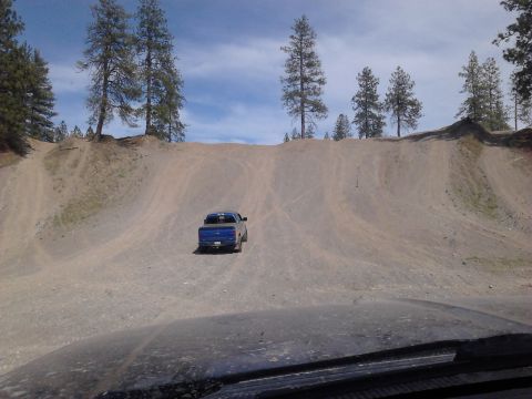 1995 Ford Bronco - Pickup truck navigates a challenging off-road terrain with a steep incline.