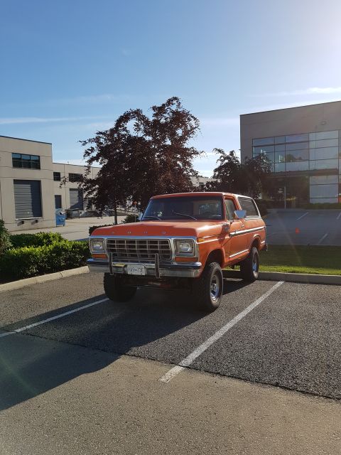 1978 Ford Bronco - This 1978 Ford Bronco is parked in a lot with modern buildings and trees visible.