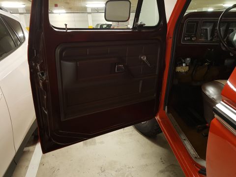 1978 Ford Bronco - Interior view of a red 1978 Ford Bronco, highlighting the door panel and dashboard details.