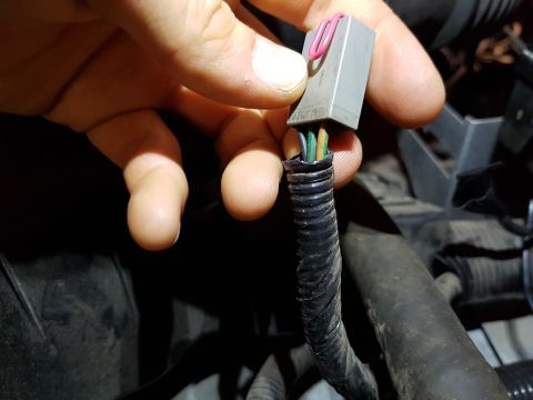 1978 Ford Bronco - A hand manipulates an electrical connector with exposed wires, suggesting a repair or diagnostic task.