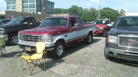 1996 Ford F-250 - A two-tone Ford F-250 pickup truck is parked in a lot with other vehicles.