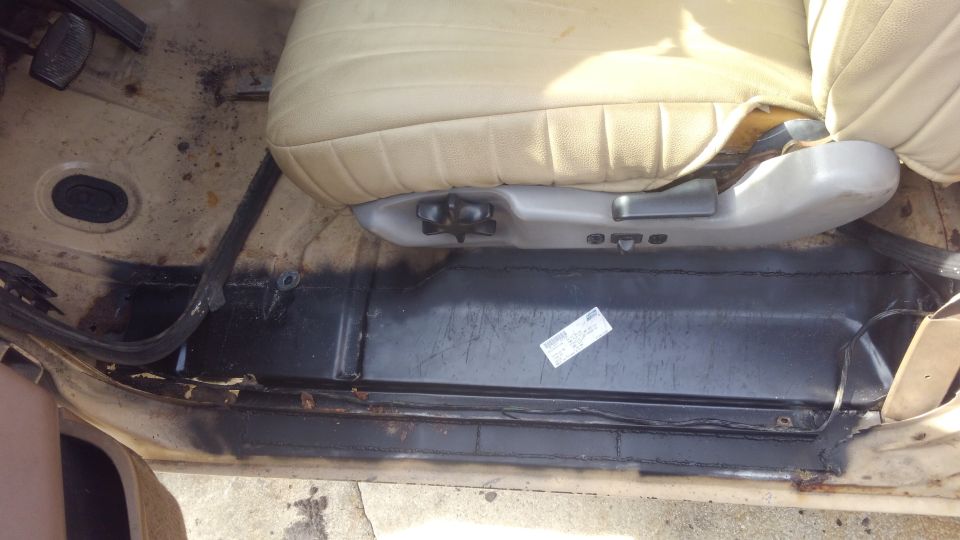 Tan vinyl seat base and black floor mat in a 1990 Ford F-250 interior