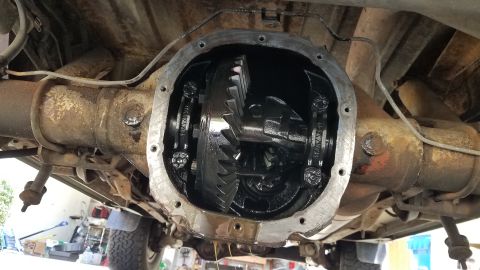 1985 Ford Bronco - Undercarriage view of an open differential housing, showing internal gears and components.