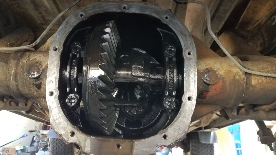 Open differential housing showing ring and pinion gears. Some bolts are visible