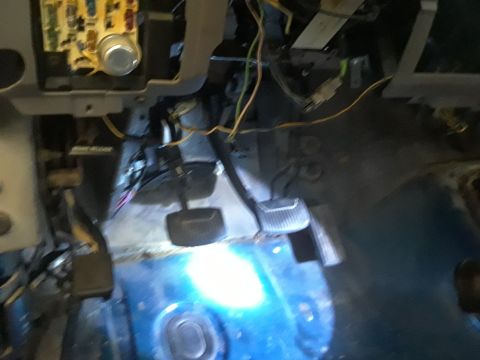 1996 Ford F-350 - The interior of a vehicle shows exposed wiring and pedals, suggesting maintenance or repair work.