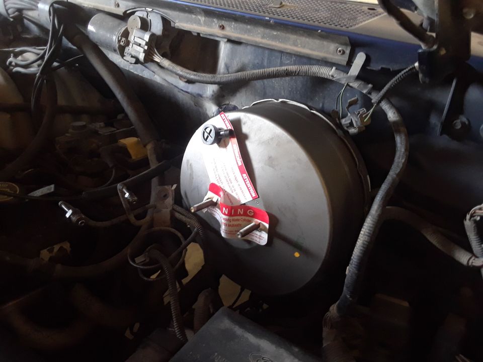 Brake booster with red warning tags and visible wiring