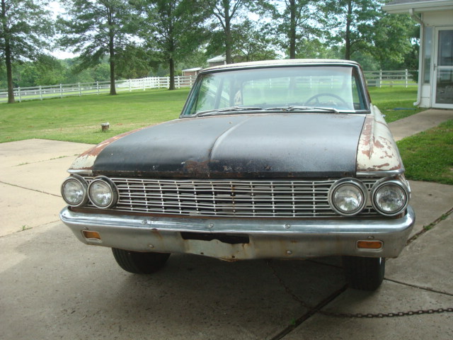 1962 Ford Galaxie front view, showing grille and dual headlights. Hood is matte black with rust spots